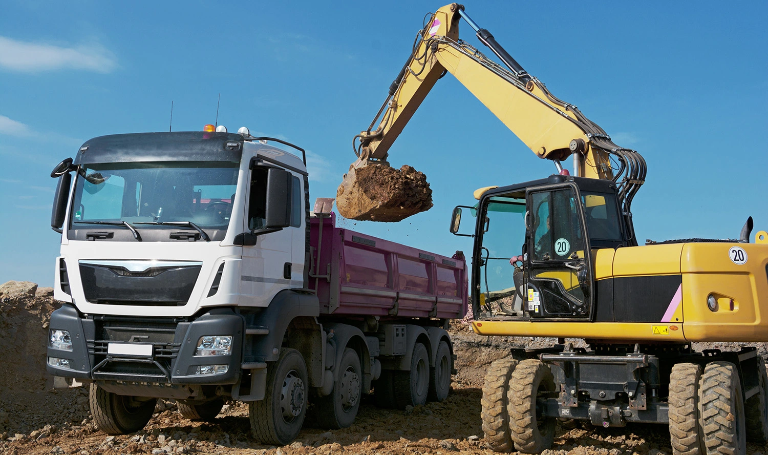Excavator loads truck
